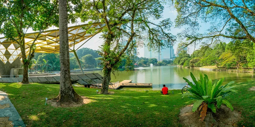 Mies rentoutuu Kuala Lumpurin Perdana Botanical Gardens -puistossa