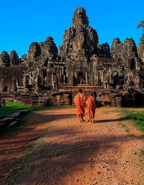 Munkit Bayon-temppelin muinaisten kivikasvojen joukossa, Angkor, Kambodža